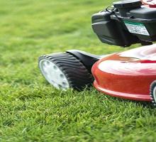 Red lawnmower going over grass