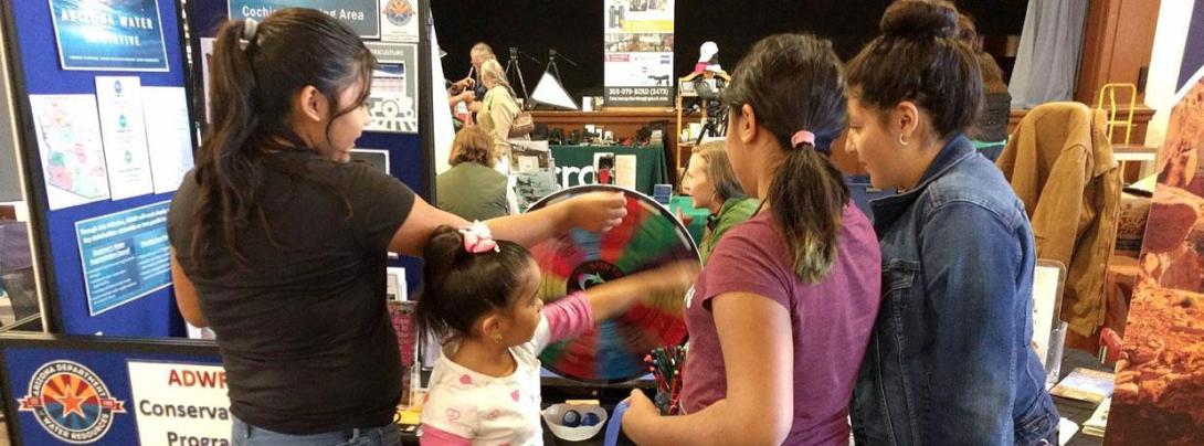 Science fair with children listening to someone who made a project on water